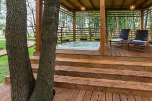 a wooden gazebo with a hot tub on a deck at Baltic Natur Park - Holiday Resort in Niechorze