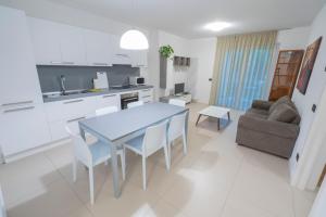 cocina y sala de estar con mesa azul y sillas en Oleeva Apartment, en Riva del Garda