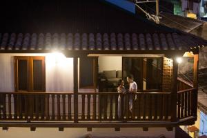 two people standing on a balcony of a house at Hotel Casa Centenario Getsemaní in Cartagena de Indias