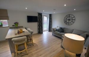 a living room with a couch and a table at Woodspurge Cottage, Drift House Holiday Cottages in Astbury