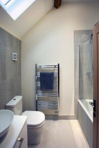 y baño con aseo, lavabo y ducha. en Woodspurge Cottage, Drift House Holiday Cottages en Astbury