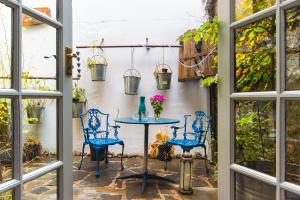 a patio with blue chairs and a table with flowers at Cleo Gallery Apartments in Kenmare