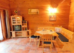 a dining room with a table and chairs and a television at Blockhaus-Ferienpark in Eisenschmitt