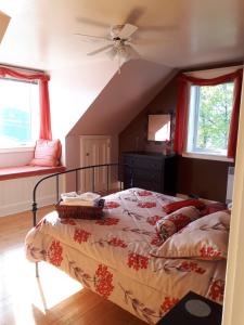 a bedroom with a bed and a ceiling fan at Dans les draps de Morphee in Campbellton