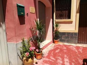 a pink building with potted plants in front of a door at Los Angeles del Romero in Gátova