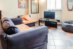sala de estar con sofá y TV en PALAZZO CORDERO APARTMENT en Parma
