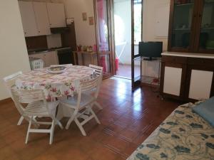 una mesa y sillas en una habitación con cocina en House Aurora, en San Nicola Arcella