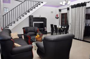 a living room with black chairs and a table at Chrish Residence in Negombo