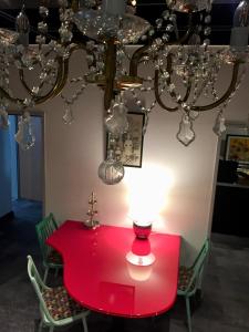 einen roten Tisch mit Stühlen und einem Kronleuchter in der Unterkunft Pension Wienderland in Wien