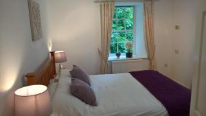 a bedroom with a white bed and a window at The Lodge in Perth