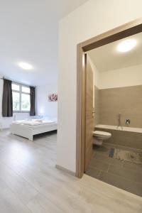 ein Bad mit einer Badewanne, einem WC und einem Bett in der Unterkunft Mary's Rooms & Apartments in Bozen