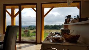 a kitchen with a table with a view of a field at Dom z Bali in Miłków
