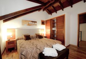 Un dormitorio con una cama grande con dos toallas blancas. en Cabañas Bosque del Nahuel, en San Carlos de Bariloche 88 fotos más