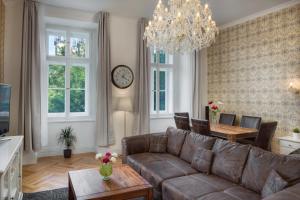 a living room with a couch and a table and a clock at Mikulášská 6 - Old Town Square View Residence in Prague