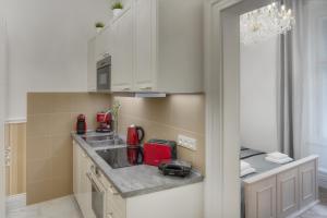a small kitchen with white cabinets and red appliances at Mikulášská 6 - Old Town Square View Apartments in Prague