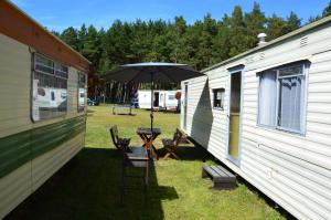 斯文托伊Jūros g. 41, Delta的一张桌子和椅子,两边有雨伞