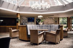 a lobby with a table and chairs and a chandelier at Manor House, Alsager in Alsager