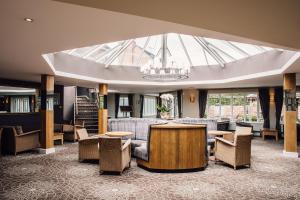 a lobby with tables and chairs and a large skylight at Manor House, Alsager in Alsager +94 photos