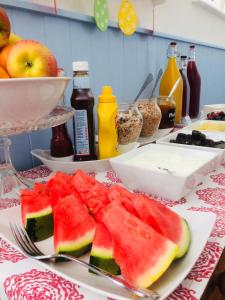 a table with a plate of watermelon and other foods at Arden House in Arundel