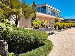 uma casa com uma palmeira em frente em Hotel Conde Navío em Sanxenxo