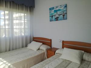 a bedroom with two beds and a picture on the wall at O Cunchal Rooms in Dena +22 photos