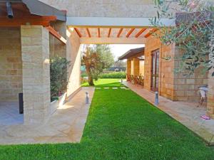 un patio al aire libre con pérgola y césped en Biancolivo Gallipoli in Salento, en Gallipoli