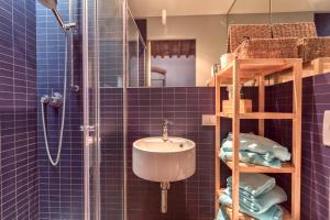 a blue tiled bathroom with a sink and a shower at Casale del Mare in Castiglioncello