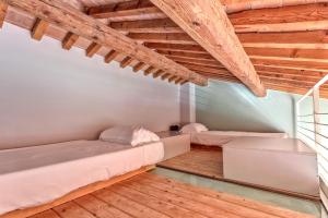 two beds in a room with wooden ceilings at Casale del Mare in Castiglioncello