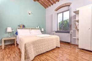 a white bedroom with a bed and a window at Casale del Mare in Castiglioncello