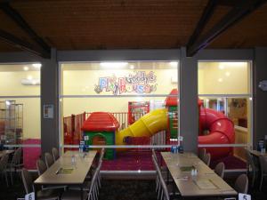 a restaurant with tables and a playground in the window at Argosy Motor Inn in Devonport