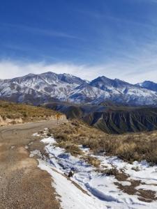 un camino de tierra con montañas en el fondo en Peatonal en Mendoza