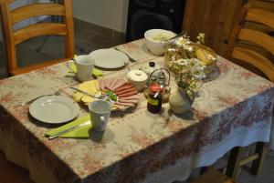 una mesa con platos de comida y flores. en Jaworowa Zagroda, en Domaszków
