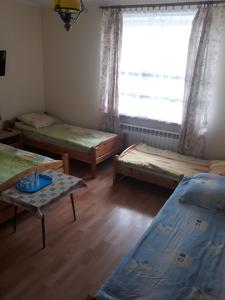 a room with three beds and a window at Uniejów Pensjonat Pod Miłorzębem in Uniejow