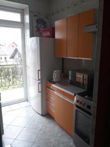 a kitchen with wooden cabinets and a stove top oven at Uniejów Pensjonat Pod Miłorzębem in Uniejow