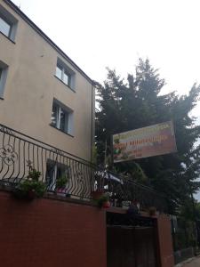 a building with a balcony with a sign on it at Uniejów Pensjonat Pod Miłorzębem in Uniejow