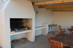 a room with a fireplace and a table and chairs at Longacre Olive & Vineyard Estate in Langebaan