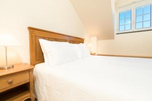 um quarto com uma cama branca e uma janela em Aguia - T1 By RMC no Funchal