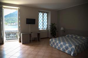 1 dormitorio con 1 cama, TV y ventana en Casa al Lago en Lecco