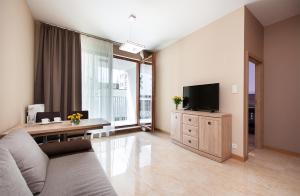 a living room with a couch and a flat screen tv at Awangarda Home Apartment in Warsaw