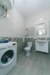 a bathroom with a washing machine and a toilet at Apartmant in Smart Plaza in Kyiv