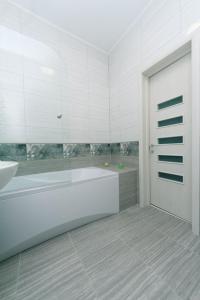 ein weißes Badezimmer mit einer Badewanne und einem Waschbecken in der Unterkunft Apartmant in Smart Plaza in Kiew