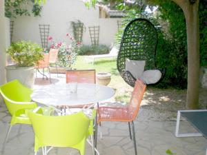 eine Terrasse mit einem weißen Tisch und Stühlen in der Unterkunft clos coutin in Gréoux-les-Bains