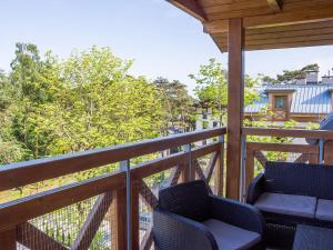 a balcony with two chairs and a railing at VacationClub - Rezydencja Park Apartament 30 in Mielno