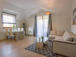 sala de estar con sofá y mesa en VacationClub - Rezydencja Park Apartament 30 en Mielno
