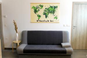 a couch in a living room with a world map on the wall at The Jungle Apartments and Rooms (Vila Džungla) in Bled