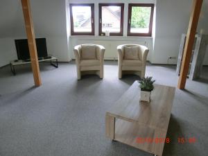 uma sala de estar com duas cadeiras e uma mesa de centro em Auf dem Lande em Harsefeld