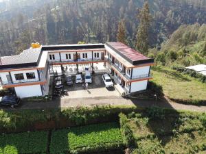 an aerial view of a house with cars parked in front at Bromo Backpacker Tosari in Pasuruan