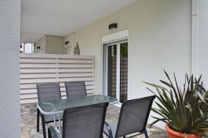 a patio with a table and chairs and plants at Mokos Rooms in Perdika