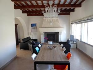 een woonkamer met een eettafel en een kroonluchter bij Villa d'architecte vue port à 2 pas de la plage in Le Grau-du-Roi