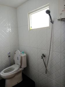 a bathroom with a toilet and a window and a shower at Bromo Backpacker Tosari in Pasuruan